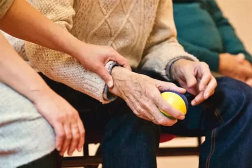 Photo of younger hands holding an older set of hands