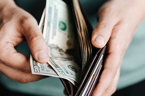 Photo of hands pulling cash out of a wallet